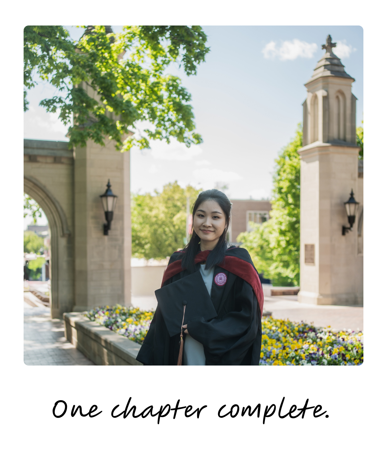 In graduation regalia at the Sample Gates — one chapter complete.